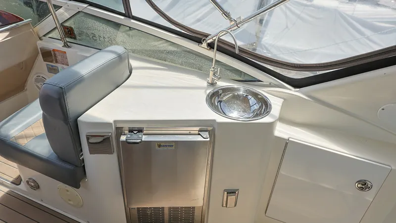 Slide: The Image of Flybridge Wet Bar with Seating This image showcases the flybridge wet bar on the 2006 Carver 396 Motor Yacht, featuring a convenient sink and a compact refrigerator. The area is complemented by comfortable seating, perfect for entertaining guests while enjoying panoramic views. The sle - 8273160