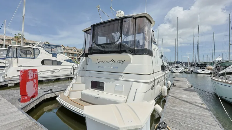 Slide: The Image of Aft Deck and Swim Platform View This image showcases the aft deck and swim platform of the 2006 Carver 396 Motor Yacht, Serendipity. The spacious aft deck features a protective canvas enclosure, offering comfort and versatility in various weather conditions. The integrated swim platform - 8273190