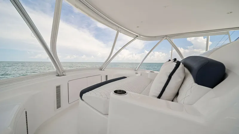 Slide: The Image of Flybridge Lounge with Ocean View This spacious flybridge lounge on the 2024 Viking 64 Convertible offers plush seating with elegant upholstery, perfect for relaxation. The expansive windows provide panoramic ocean views, enhancing the open-air experience. Sleek, modern design elements em - 7541871