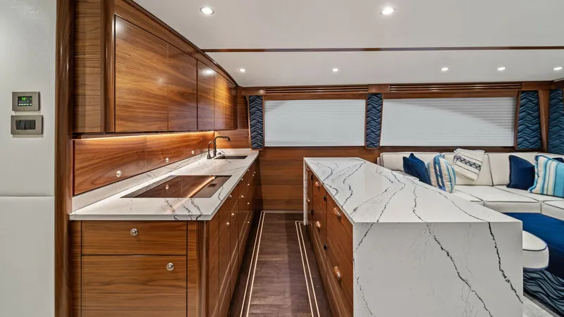 Slide: The Image of Galley with Marble Countertops The galley of the Southern Grace, a 2024 Viking 64 Convertible, features luxurious marble countertops and rich wood cabinetry, offering a sleek and modern aesthetic. The ample counter space and integrated sink provide functionality for gourmet meal prepar - 7541823