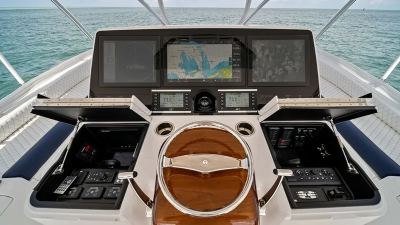 Slide: The Image of Flybridge Helm Station The helm station on the Viking 64 Convertible offers state-of-the-art navigation with multi-function displays and advanced controls. The polished wooden steering wheel is complemented by a sleek, modern dashboard layout, ensuring a commanding view and int - 7541858