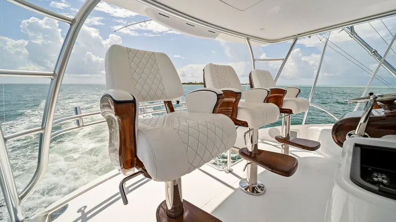 Slide: The Image of Flybridge Helm Seating Area This luxurious flybridge of the 2024 Viking 64 Convertible features plush, diamond-stitched helm chairs with elegant wooden accents, offering supreme comfort and style. The open layout provides breathtaking panoramic views, enhancing the sense of freedom - 7541861
