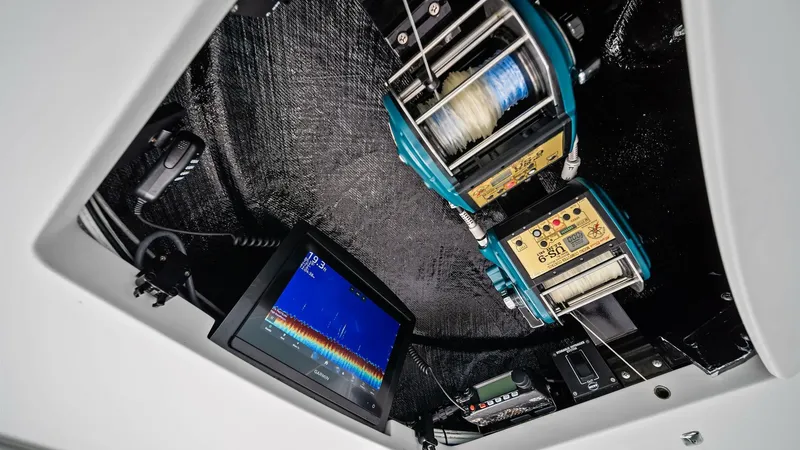 Slide: The Image of Advanced Fishing Equipment Compartment This image showcases the advanced fishing equipment compartment on the Viking 64 Convertible, Southern Grace. The setup features state-of-the-art electric reels and a high-resolution fish finder display, offering optimal functionality for serious anglers. - 7541867