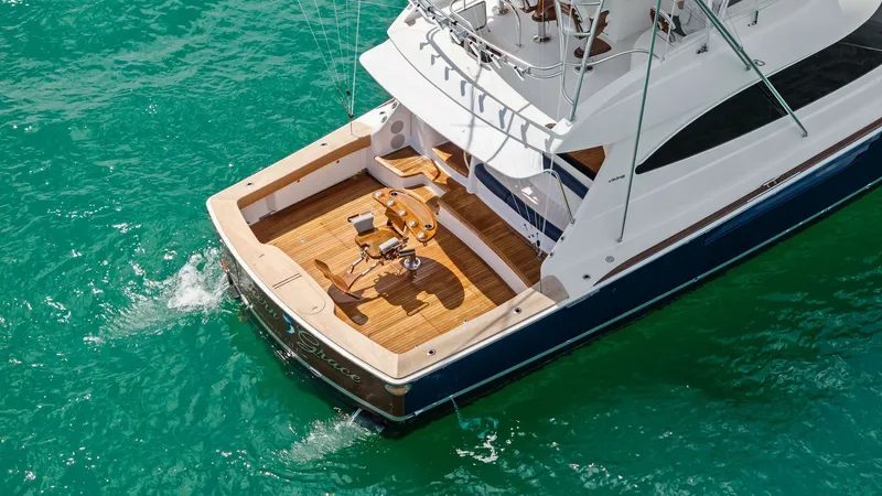Slide: The Image of Spacious Aft Deck with Fishing Setup The Southern Grace's aft deck offers an expansive space designed for fishing enthusiasts, featuring a premium fighting chair and ample rod holders. The teak decking enhances the luxurious feel, while the open layout ensures easy movement and accessibility - 7541884