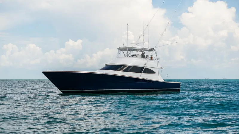 Slide: The Image of Profile View of Viking 64 Convertible The Southern Grace, a 2024 Viking 64 Convertible, showcases its sleek profile against a serene ocean backdrop. The yacht's elegant lines and robust structure speak to its superior craftsmanship and performance capabilities. The flybridge is equipped with - 7541885