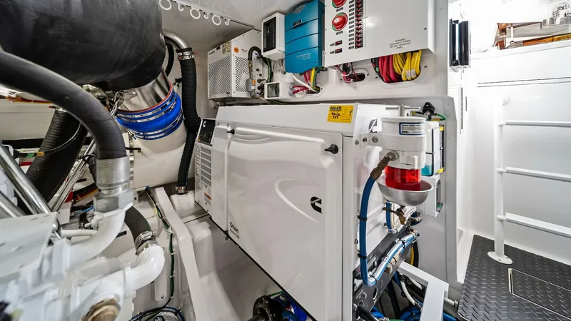Slide: The Image of Engine Room with Generator System The engine room of the 2024 Viking 64 Convertible 'Southern Grace' is meticulously organized, showcasing a state-of-the-art generator system. This space is designed for efficiency and accessibility, featuring advanced electrical panels and neatly arranged - 7541875
