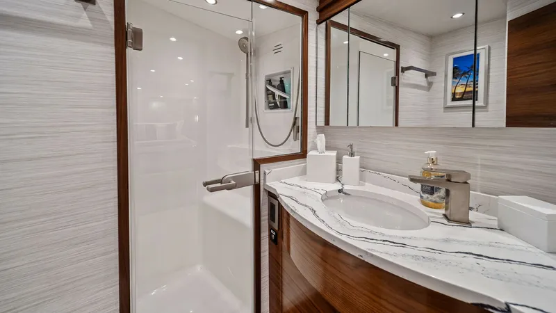 Slide: The Image of Luxurious Ensuite Bathroom The ensuite bathroom of the Southern Grace offers a sleek and modern design, featuring exquisite wood cabinetry and a pristine white countertop. A spacious shower with a glass door adds a touch of elegance and functionality. The well-lit space is accentua - 7541844