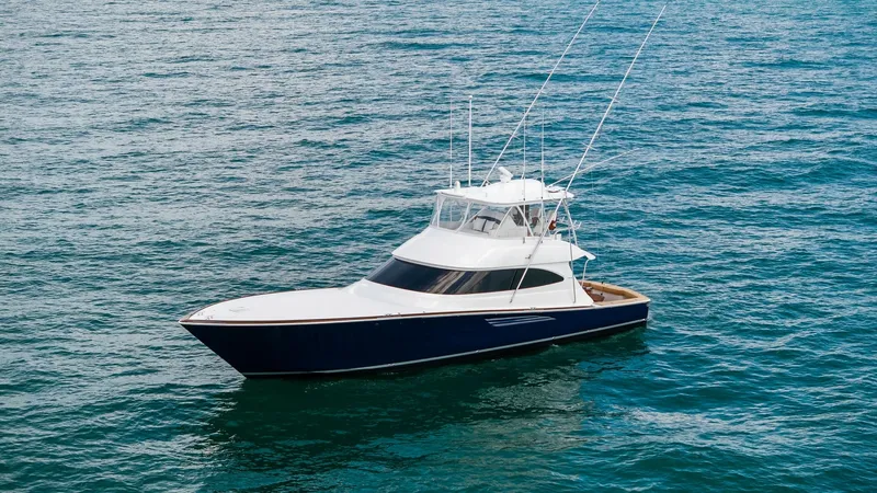 Slide: The Image of Aerial View of Viking 64 Convertible The 2024 Viking 64 Convertible, Southern Grace, is showcased elegantly on open waters, highlighting its sleek, modern design. The vessel's deep blue hull contrasts beautifully with the white superstructure, while the spacious flybridge offers commanding v - 7541887