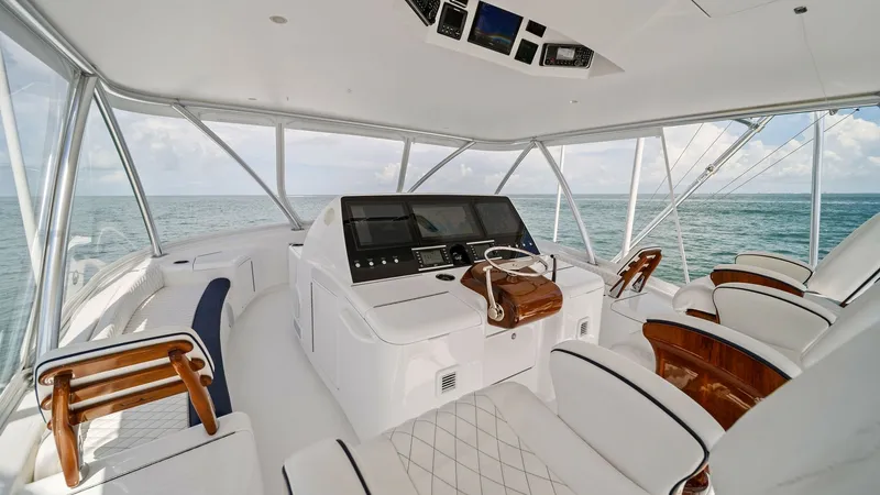 Slide: The Image of Flybridge Helm with Panoramic Views The flybridge helm of the 2024 Viking 64 Convertible offers commanding views with its wraparound windows. The sleek, modern console is equipped with state-of-the-art navigation technology, complemented by elegant wood and leather finishes. Ample seating e - 7541864