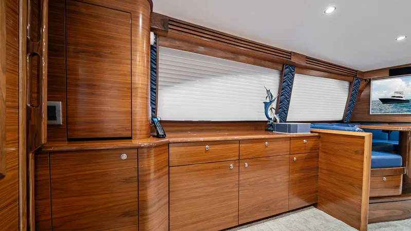 Slide: The Image of Salon Cabinetry and Seating Area This image showcases the exquisite salon cabinetry of the 2024 Viking 64 Convertible, Southern Grace. The rich wood finishes complement the sleek, modern design, offering ample storage while enhancing the yacht's luxurious ambiance. Accentuated by soft li - 7541826