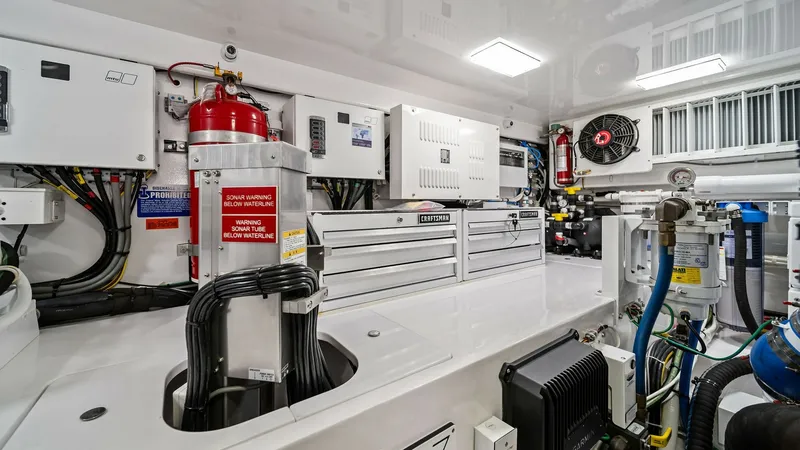 Slide: The Image of Engine Room with Equipment Storage The engine room of the 2024 Viking 64 Convertible 'Southern Grace' showcases a meticulously organized space featuring advanced mechanical systems and ample storage. Visible are state-of-the-art electrical panels, essential safety equipment, and neatly arr - 7541878
