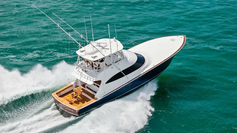 Slide: The Image of Aerial View of Flybridge and Deck This image showcases the Viking 64 Convertible's sleek exterior as it cuts through the water. The flybridge offers an elevated vantage point, perfect for commanding views while navigating. The spacious aft deck features a well-appointed seating area, idea - 7541901
