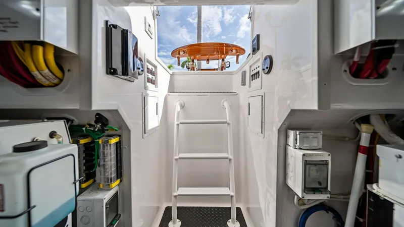 Slide: The Image of Engine Room Access and Control Panel The image showcases the well-organized engine room access of the 2024 Viking 64 Convertible, featuring a sturdy ladder leading to the deck. The area is equipped with essential control panels and neatly arranged utility components, emphasizing functionalit - 7541882