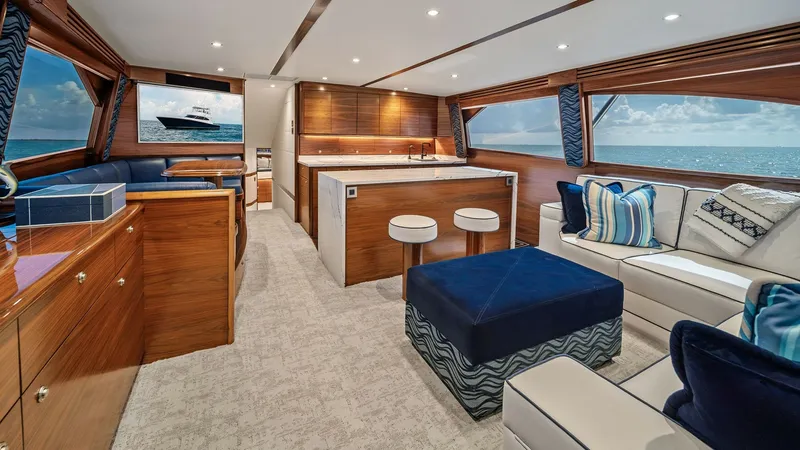 Slide: The Image of Spacious Salon with Ocean Views The salon of the 2024 Viking 64 Convertible exudes luxury and comfort with its modern design and expansive ocean views. Rich wood finishes and plush seating create an inviting atmosphere, while large windows flood the space with natural light. The integra - 7541810