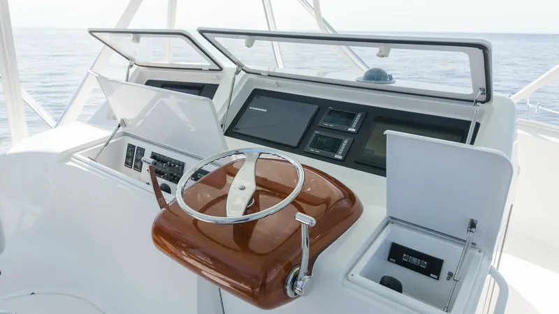 Slide: The Image of 2009 Viking 50 Convertible " Jammin" - A Polished Stainless Steel Steering Wheel, Complemented by a Beautifully Finished Wood Helm Base and a Crisp White Helm Station, Creates a Refined and Timeless Command Center. The helm station on the 2009 Viking 50 Convertible 'Jammin' features a sleek, modern design with state-of-the-art navigation equipment. The varnished wooden steering wheel adds a touch of classic elegance, while the dual display screens provide comprehens - 7018182