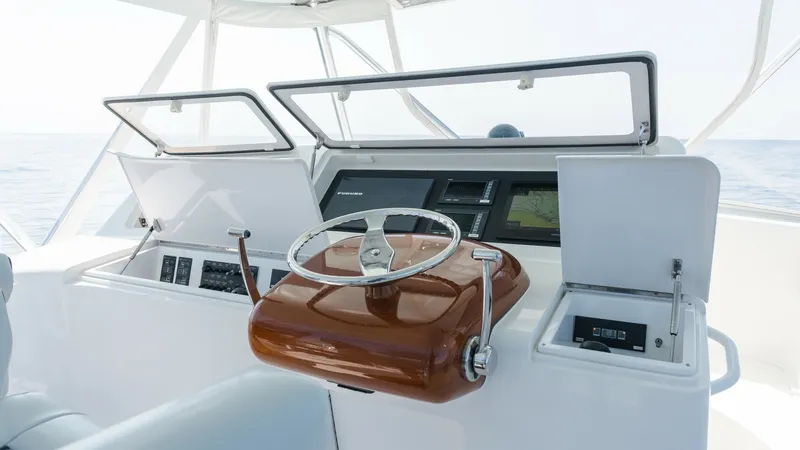 Slide: The Image of 2009 Viking 50 Convertible "Jammin" - Sleek and Polished Helm Station The helm station of the 2009 Viking 50 Convertible features a sleek, polished wooden wheel, complemented by an array of modern navigational instruments. The clean, white console provides ample space for electronics, ensuring a seamless command experience. - 7018169
