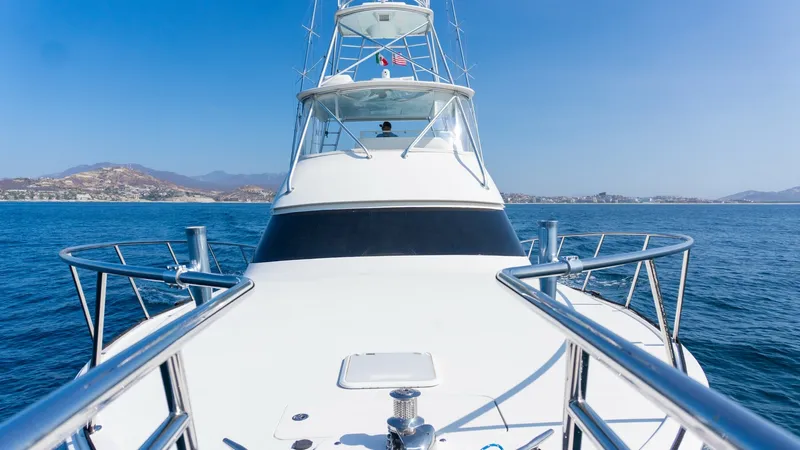 Slide: The Image of 2009 Viking 50 Convertible "Jammin" - Bow View This image showcases the sleek bow of the 2009 Viking 50 Convertible, 'Jammin'. The polished stainless steel rails and robust anchor system highlight the vessel's durability and elegance. The towering flybridge provides an excellent vantage point for navi - 7018179