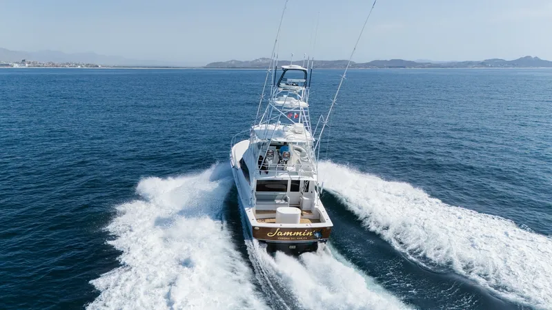 Slide: The Image of 2009 Viking 50 Convertible "Jammin" - Aft View Underway The Viking 50 Convertible 'Jammin' is captured in motion, showcasing its powerful performance and sleek design. The vessel's spacious aft deck and distinctive tuna tower are highlighted against a backdrop of open sea. The wake trailing behind emphasizes t - 7018229