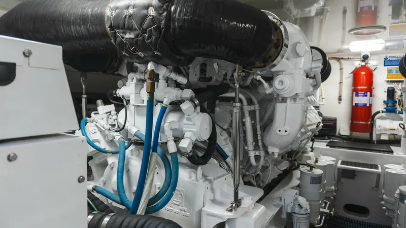Slide: The Image of 2009 Viking 50 Convertible "Jammin" - Engine Room with Diesel Engine This image showcases the meticulously maintained engine room of the 2009 Viking 50 Convertible, featuring a robust diesel engine. The space is designed for optimal performance, with accessible plumbing and wiring for easy maintenance. Bright lighting and - 7018214