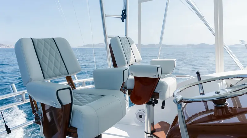 Slide: The Image of 2009 Viking 50 Convertible "Jammin" - The Flybridge features Premium Captain's Chairs that Combine Comfort, Functionality, and Commanding Sightlines for an Elevated Boating Experience. The flybridge of the 2009 Viking 50 Convertible features plush, diamond-stitched helm chairs offering supreme comfort and style. The open design provides excellent visibility and a commanding view of the ocean, perfect for navigation. The polished wood an - 7018181