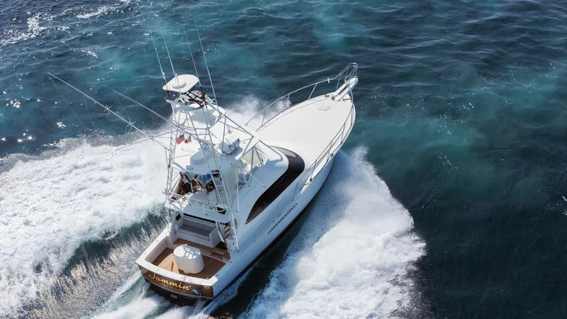 Slide: The Image of 2009 Viking 50 Convertible "Jammin" - Aft-starboard view highlighting the yacht's graceful profile and on-water presence. This stunning aerial shot captures the Viking 50 Convertible, 'Jammin,' cruising through open waters with dynamic power and grace. The vessel's sleek design and spacious aft deck are highlighted, showcasing its capabilities as an exceptional sportfishing - 7018227