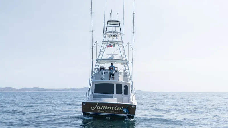 Slide: The Image of 2009 Viking 50 Convertible "Jammin" The 2009 Viking 50 Convertible 'Jammin' is showcased from the stern, highlighting its sleek design and robust tower. The spacious cockpit is ideal for serious anglers, while the flybridge offers excellent visibility and control. The vessel's name and home - 7018216
