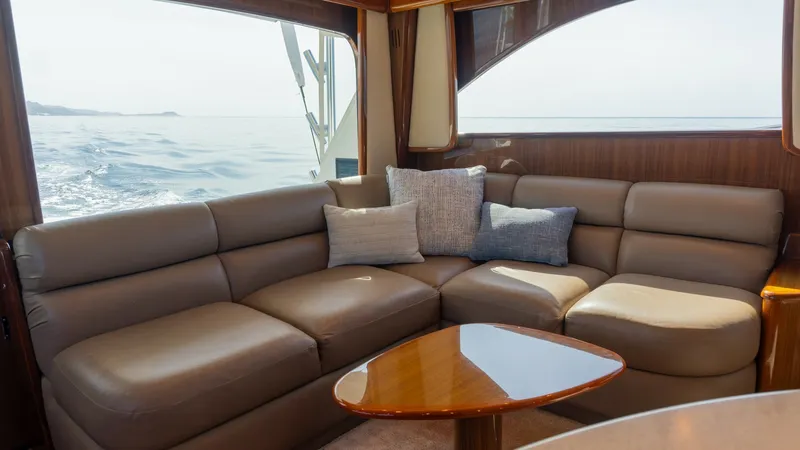 Slide: The Image of 2009 Viking 50 Convertible "Jammin" - Salon Lounge with Ocean Views The salon of the 2009 Viking 50 Convertible offers a luxurious, spacious seating area with plush leather upholstery and elegant wood finishes. Large windows provide breathtaking ocean views, enhancing the relaxing atmosphere. The sleek design and comforta - 7018193