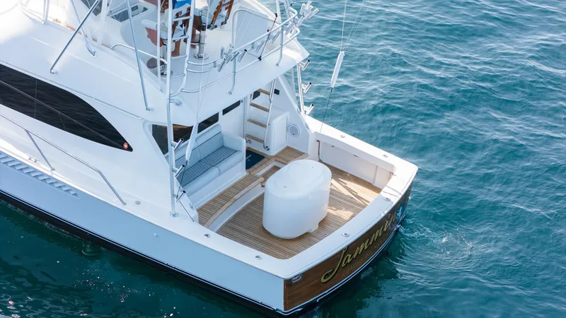 Slide: The Image of 2009 Viking 50 Convertible "Jammin" - Spacious Aft Deck with Livewell station The aft deck of the 2009 Viking 50 Convertible, 'Jammin', features a spacious layout ideal for both relaxation and fishing. With elegant teak flooring and comfortable built-in seating, this area is designed for leisure and functionality. The deck offers e - 7018173