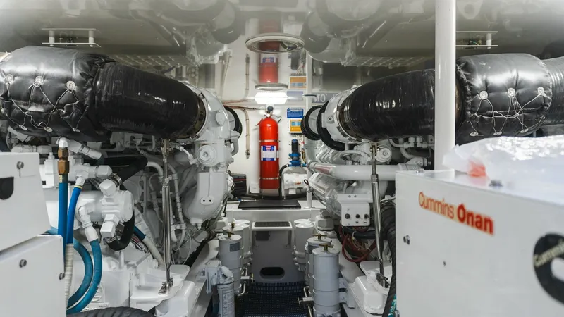 Slide: The Image of 2009 Viking 50 Convertible "Jammin" - Engine Room with Twin Engines The engine room of the 2009 Viking 50 Convertible 'Jammin' boasts powerful twin engines, meticulously organized for optimal performance. The space is well-lit and features high-quality insulation, ensuring efficient operation and sound reduction. Notable - 7018213