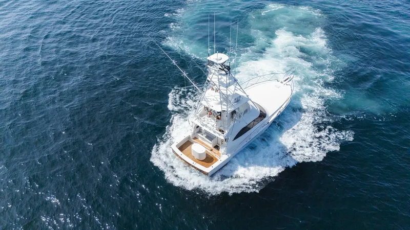Slide: The Image of 2009 Viking 50 Convertible "Jammin" - Backing Down This dynamic aerial shot of the 2009 Viking 50 Convertible 'Jammin' showcases its sleek lines and powerful presence on the water. The vessel features a spacious cockpit designed for both sportfishing and leisure, complemented by a commanding flybridge. Th - 7018218