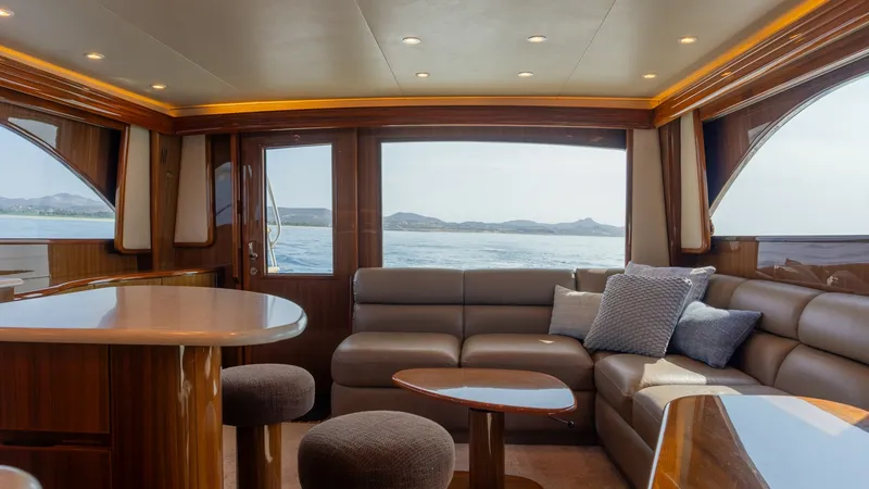 Slide: The Image of 2009 Viking 50 Convertible "Jammin" - A Warm and Welcoming Salon and Galley with Expansive Ocean Views. The salon of the 2009 Viking 50 Convertible 'Jammin' offers a luxurious and inviting space with panoramic ocean views. It features plush leather seating, elegant wood finishes, and ample natural light through large windows. Perfect for relaxation or enter - 7018170