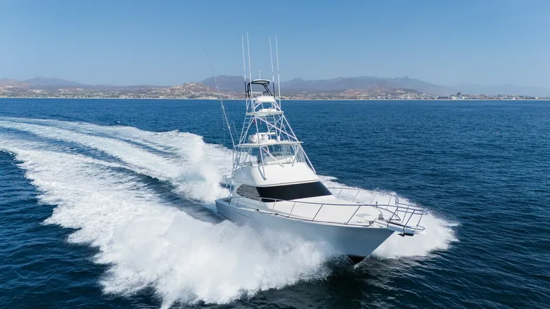 Slide: The Image of 2009 Viking 50 Convertible "Jammin" - Starboard Bow View Highlighting the Yacht's Graceful Profile and On-Water Presence. The 2009 Viking 50 Convertible, 'Jammin,' cuts elegantly through the water, showcasing its sleek bow and robust construction. The sharp lines and aerodynamic design highlight its performance capabilities, while the flybridge offers excellent visibility. T - 7018224