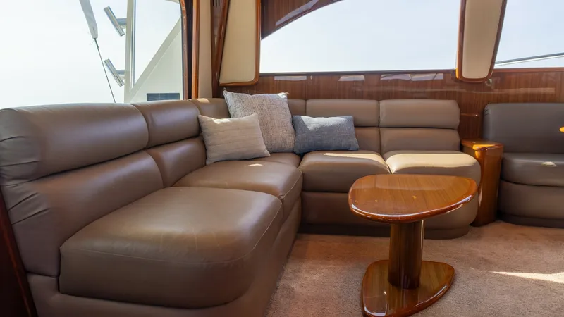 Slide: The Image of 2009 Viking 50 Convertible "Jammin" - Salon The salon of the 2009 Viking 50 Convertible offers plush leather seating, creating a comfortable and inviting space. The area features a stylish wooden coffee table, adding elegance to the cozy setting. Large windows provide ample natural light and offer - 7018192