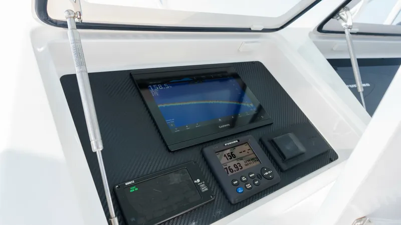 Slide: The Image of 2009 Viking 50 Convertible "Jammin" - Helm Station Electronics Display The helm station of the 2009 Viking 50 Convertible 'Jammin' features a state-of-the-art electronics display. The dashboard is equipped with advanced navigation and communication systems, housed in a sleek, carbon-fiber panel. This setup ensures precise co - 7018187