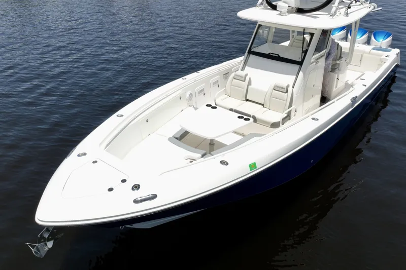 Slide: The Image of Bow from above  Bow sun pad, console seating, helm, and triple Yamahas in calm water - 6788455