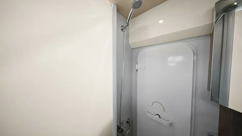 Slide: The Image of Modern Ensuite Shower Area This sleek ensuite shower area on the Absolute 52 Navetta features a contemporary design with a high-quality handheld showerhead and elegant fixtures. The clean, minimalist aesthetic is enhanced by soft lighting and a glossy finish, creating a comfortable - 6851834