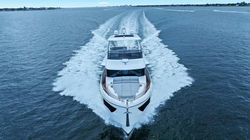 Slide: The Image of Bow Aerial View in Motion This striking aerial view showcases the Absolute 52 Navetta's sleek bow cutting through the water, highlighting its dynamic design and powerful performance. The expansive forward sunpad offers a luxurious space for relaxation while cruising. The vessel's - 6851859