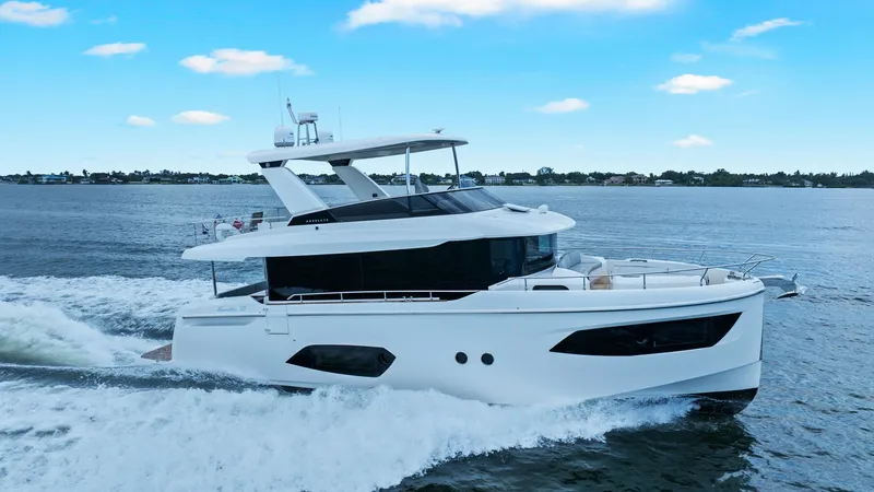 Slide: The Image of Port Side Profile Underway The 2024 Absolute 52 Navetta 'One More' glides effortlessly through the water, showcasing its sleek and modern design. The expansive windows on the port side allow for abundant natural light and panoramic views. Its elegant lines and robust structure are - 6851861