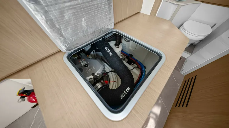 Slide: The Image of Engine Access Hatch in Cabin This image showcases the engine access hatch in the cabin of the Absolute 52 Navetta, providing easy maintenance access. The hatch is seamlessly integrated into the sleek wooden cabinetry, ensuring a clean and modern look. The surrounding area features lu - 6851836
