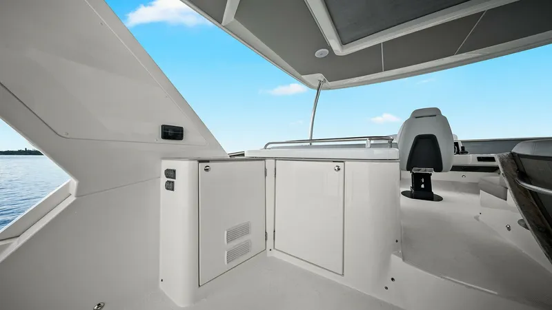 Slide: The Image of Flybridge Helm Station and Lounge Area The flybridge of the 2024 Absolute 52 Navetta offers a sleek and modern helm station, complemented by a comfortable lounge area. The spacious layout provides ample seating and storage, ideal for both navigation and relaxation. A retractable sunshade canop - 6851780