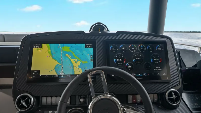 Slide: The Image of Modern Helm Station This state-of-the-art helm station on the 2024 Absolute 52 Navetta features dual multifunction displays, providing comprehensive navigation and system monitoring. The sleek carbon fiber finish and ergonomic steering wheel enhance the control experience, e - 6851813