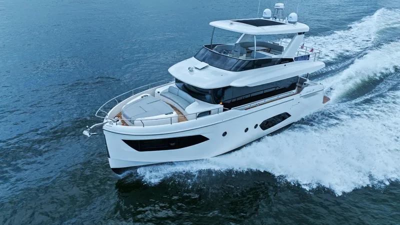Slide: The Image of Aerial View of Navetta 52 Cruising This dynamic aerial shot captures the Absolute 52 Navetta, 'One More', gliding gracefully through the water. The sleek design features a spacious foredeck with luxurious sun pads and a modern flybridge, offering panoramic views. The vessel's elegant lines - 6851866