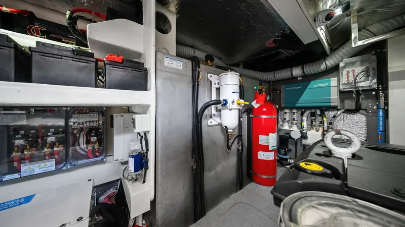 Slide: The Image of Engine Room with Equipment Overview This image showcases the meticulously organized engine room of the Absolute 52 Navetta. Visible are key components such as the battery system, fire suppression unit, and advanced control panels, all indicative of high-quality engineering. The space is wel - 6851846