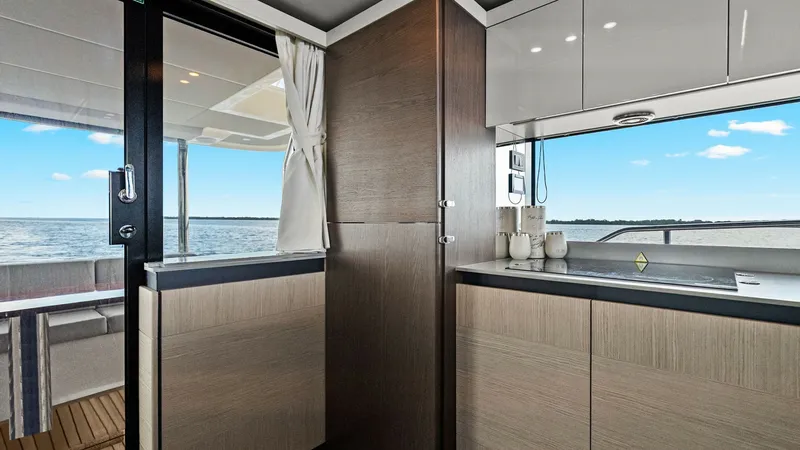 Slide: The Image of Galley with Ocean View This elegant galley on the Absolute 52 Navetta boasts modern cabinetry and sleek countertops, providing ample space for culinary creations. The large sliding door opens to a stunning ocean view, enhancing the sense of openness and connection to the sea. N - 6851798