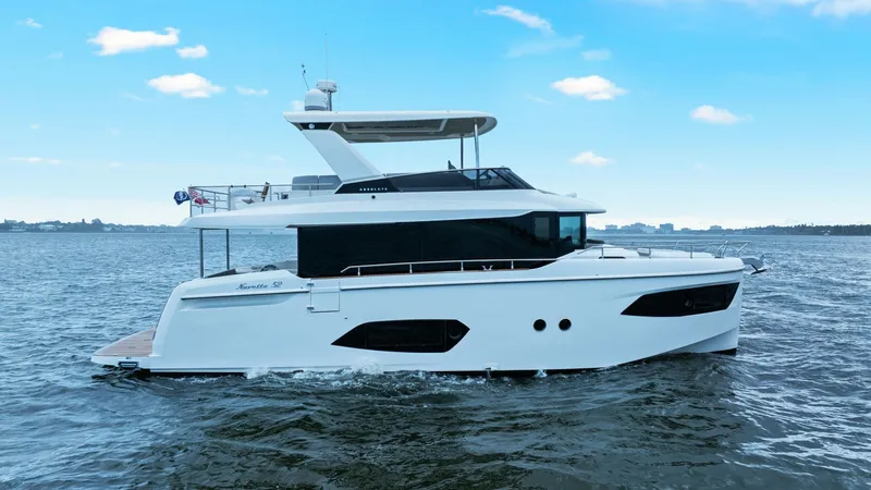 Slide: The Image of Starboard Side Profile in Motion The sleek starboard side profile of the 2024 Absolute 52 Navetta, 'One More,' showcases its modern design and spacious layout. The elegant white hull is complemented by expansive windows, providing stunning panoramic views and ample natural light. The fly - 6851848