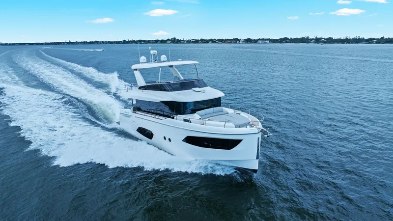 Slide: The Image of Aerial View of 52 Navetta Cruising The Absolute 52 Navetta glides smoothly over the water, showcasing its sleek design and impressive performance. The flybridge offers a commanding view, perfect for navigating coastal waters. With its modern lines and spacious deck, this vessel combines lu - 6851858