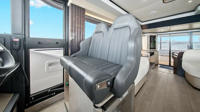 Slide: The Image of Helm Seating and Cockpit Access This image showcases the helm seating area of the 2024 Absolute 52 Navetta. The elegant, padded helm chairs offer comfort and style, providing an excellent vantage point for navigation. The layout includes easy access to the cockpit, enhancing the seamles - 6851812
