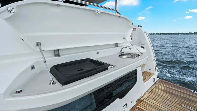 Slide: The Image of Aft Deck Grill and Sink Area This image showcases the aft deck of the Absolute 52 Navetta, featuring a convenient outdoor grill and sink setup. The integrated grill and stainless steel sink are ideal for alfresco dining while enjoying the open water views. The sleek design and easy a - 6851873