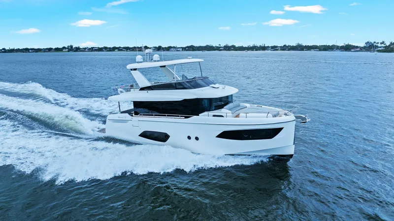 Slide: The Image of Side Profile of Absolute 52 Navetta This sleek side profile of the 2024 Absolute 52 Navetta showcases its elegant lines and modern design. The vessel's expansive windows and streamlined hull highlight its sophisticated style and luxurious appeal. The spacious flybridge offers excellent vant - 6851857