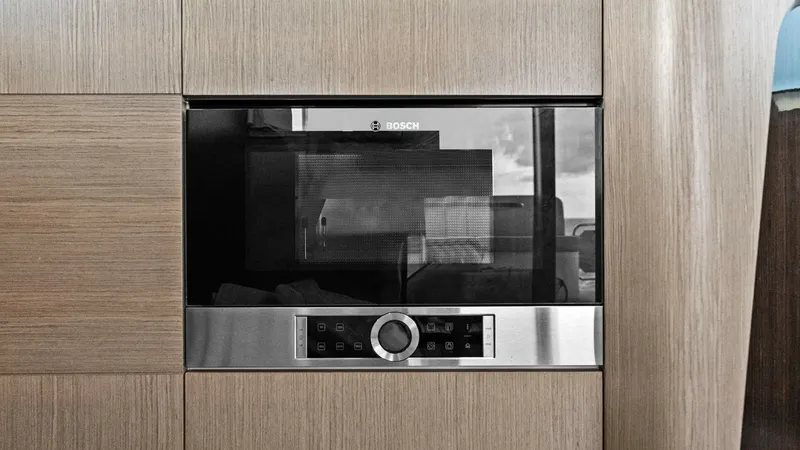 Slide: The Image of Modern Galley with Built-in Oven This image showcases the sleek galley of the 2024 Absolute 52 Navetta. The built-in Bosch oven is seamlessly integrated into the elegant wood cabinetry, offering a modern and functional cooking space. The use of premium materials and stylish finishes enha - 6851802